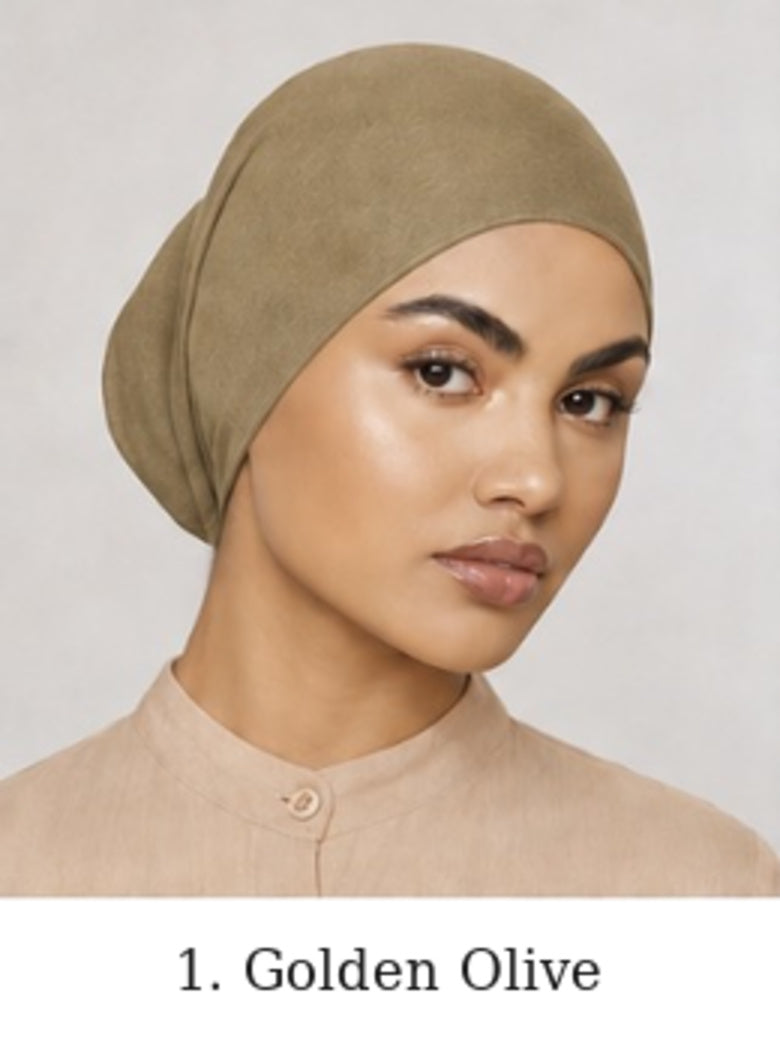 A woman wearing a soft, draped head covering in a golden-olive shade, shown against a light gray background with the text '1. Golden Olive' below.